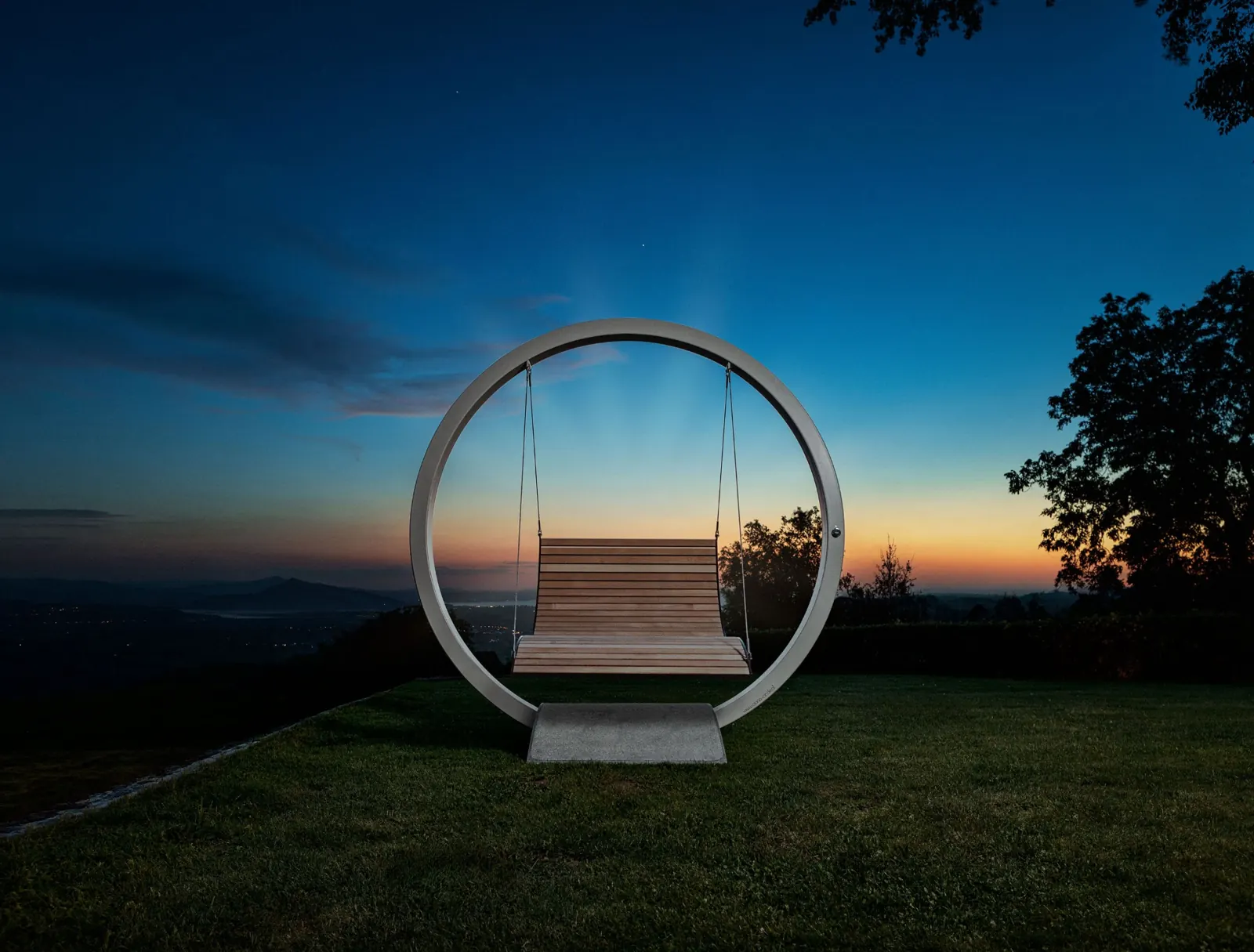oona circle Schaukelbank im Edelstahlring bei Abenddämmerung über dem Rheintal